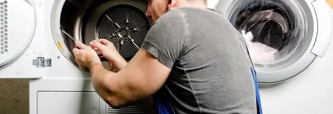 Dryer repair technician fixing a clothes dryer drum in Boston, MA