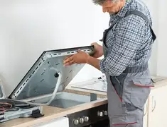 Appliance repair technician installing a built-in cooktop in Boston, MA