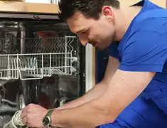Dishwasher repair technician inspecting and servicing an open dishwasher in Boston, MA