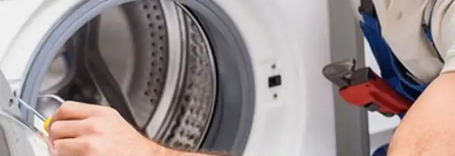 Appliance technician repairing a clothes dryer drum and internal parts in Boston, MA