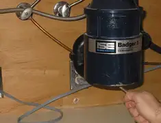 Garbage disposal repair technician tightening the mounting ring under a sink in Boston, MA