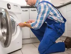 Washing machine repair technician servicing a front-load washer in Boston, MA