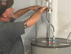 Water heater repair technician tightening supply line connections in Boston, MA